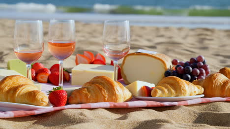 beach picnic with wine, cheese, and croissants