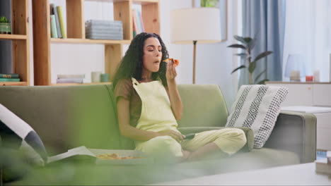 woman eating pizza on the couch