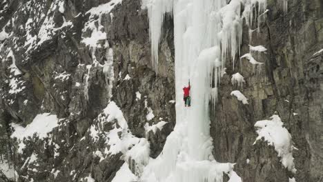 spectacular aerial view ice climber scaling frozen cascade in maineline, kineo