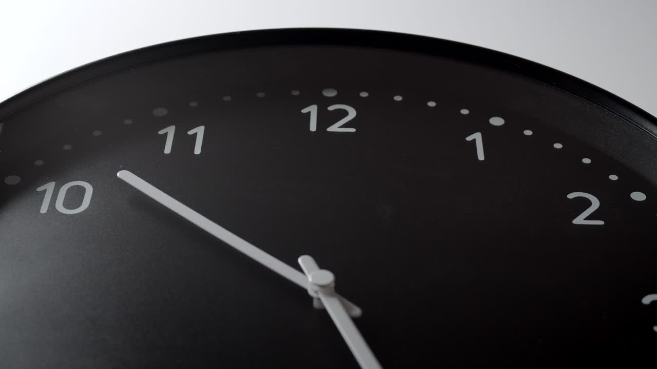 reloj negro de 10 a 2 horas en la pared blanca