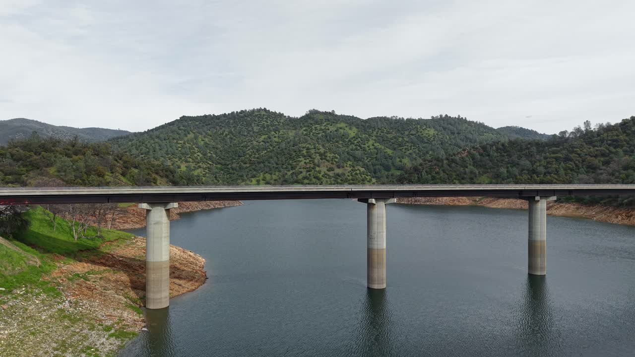 A static aerial view highlights the Don Pedro Reservoir Bridge as it cuts through the serene waters below.