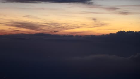 Aerial-shot-of-Clouds-during-sunset,-blue-hour,-view-from-airplane-window
