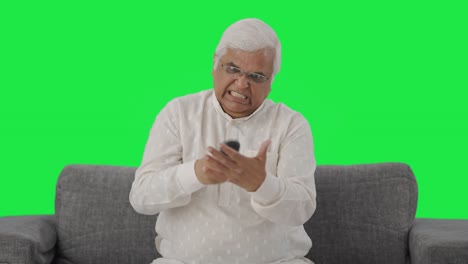 Angry-Indian-old-man-trying-to-fix-TV-remote-Green-screen