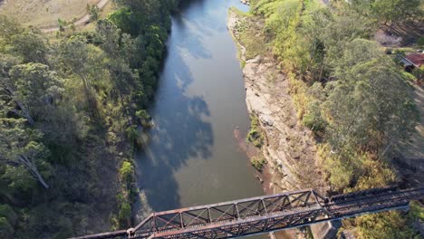 Volando-Sobre-El-Puente-Del-Ferrocarril-Sobre-El-Río-Richmond-Con-Pilotes-De-Madera-Debajo