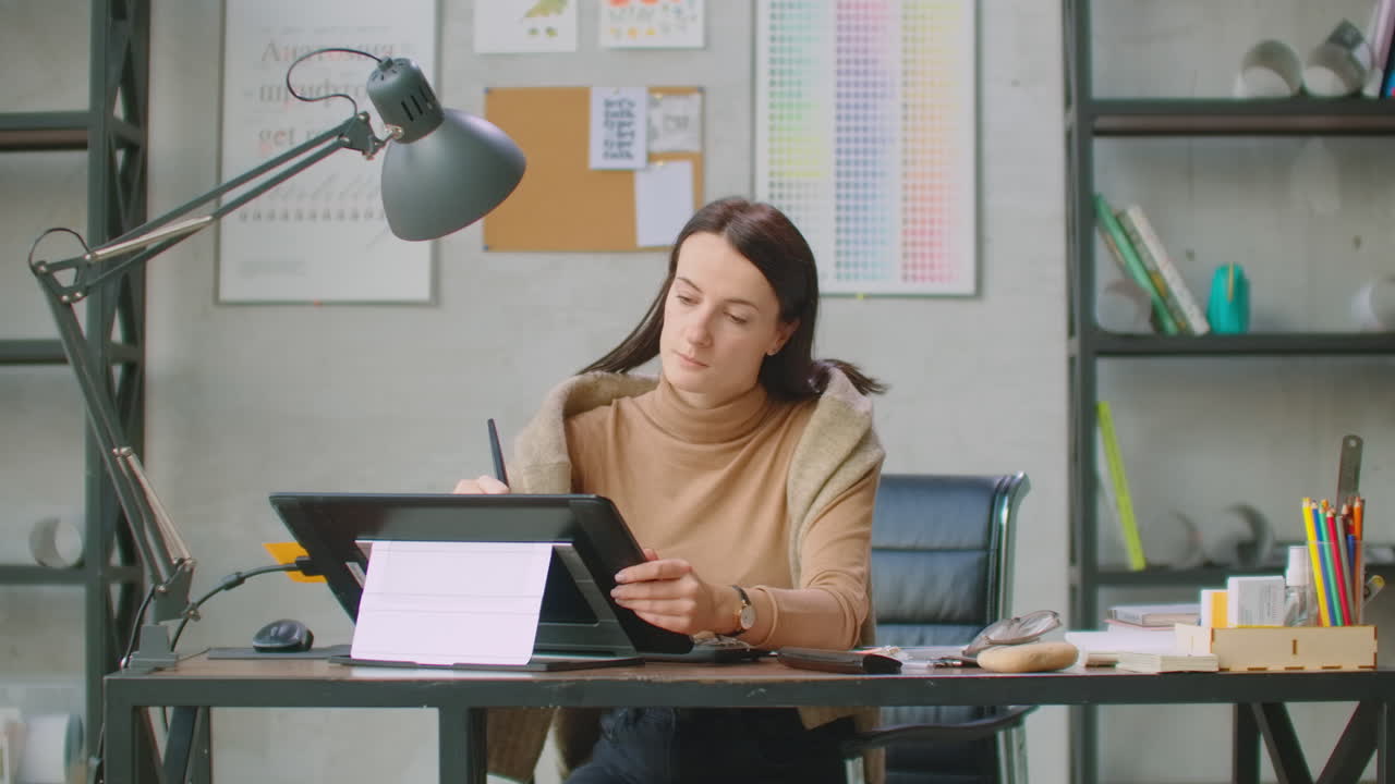 Female graphic designer working on computer. Mid section of young pretty Asian female graphic designer working on computer at desk in office. This is a casual