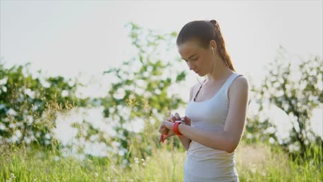 woman exercising outdoors with smartwatch and headphones