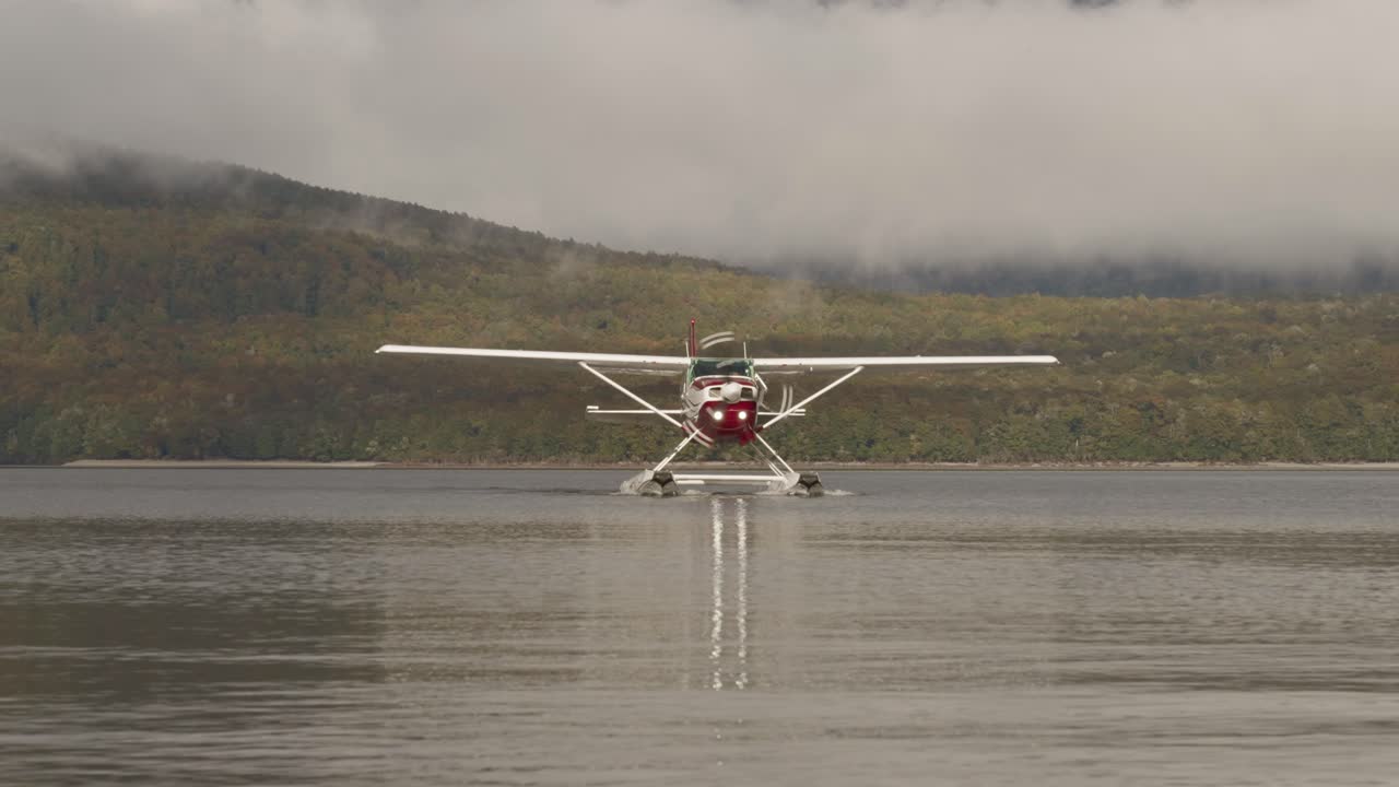 잔잔한 호수에서 회전하는 프로펠러로 카메라를 향해 움직이는 수상 비행기