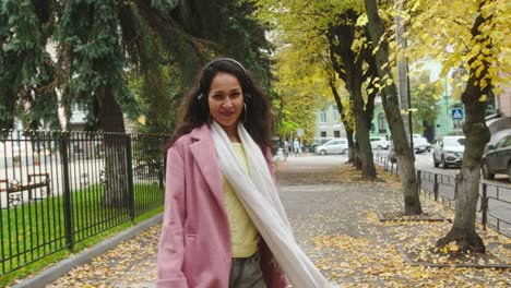 mujer encantada escuchando música en la calle y dando la vuelta
