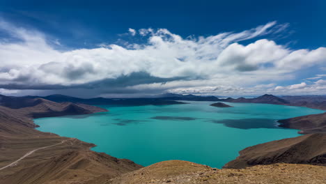turquoise lake surrounded by mountains under a dynamic sky