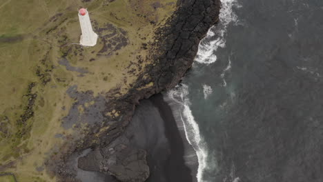 dramaric icelandic landscape with lighthouse on the cliffs