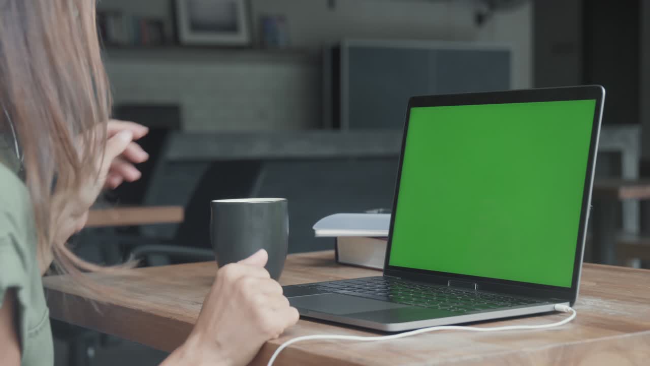 persona que utiliza una computadora portátil con pantalla verde