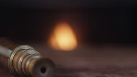 hand picks up glass of bourbon whiskey next to vintage brass telescope