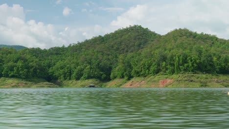 Imágenes-Panorámicas-De-La-Naturaleza-Del-Paisaje-Cinematográfico-De-4k-Del-Lago-De-La-Presa-Mae-Kuang-En-Doi-Saket,-Norte-De-Tailandia-En-Un-Día-Soleado-Mientras-Navega-En-Un-Bote-En-Movimiento,-Cerca-Del-Agua