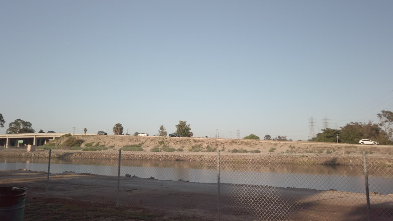 pan con carretera, arboles, canal y autos