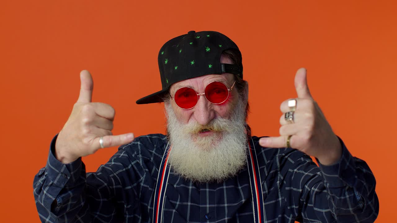 encantado encantado loco anciano mostrando gesto de rock n roll con las manos, signo fresco, baile