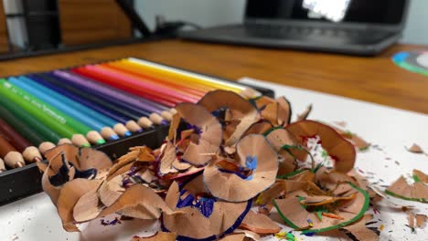 panoramic shot of a pile of crayon shavings and sharpened pencils in the background