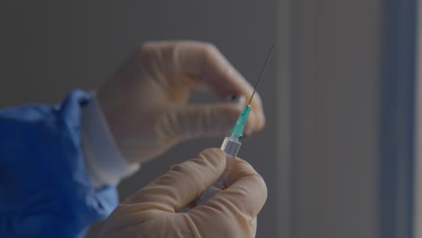 primer plano de un trabajador sanitario de primera línea agitando suavemente un vial de vacuna contra el covid mientras se preparan para inocular a los pacientes