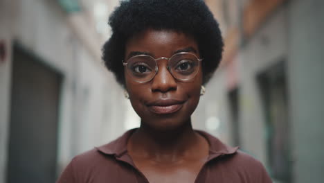 Primer-Plano-De-Una-Hermosa-Mujer-Africana-Con-Gafas-Luciendo-Feliz-Al-Aire-Libre