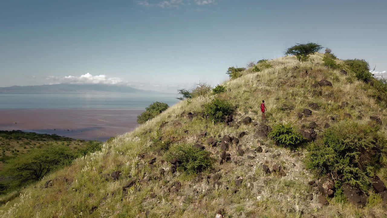 vista aérea frontal de los excursionistas que alcanzan la cima de una montaña en tanzania, áfrica oriental, dando paso a un hermoso paisaje