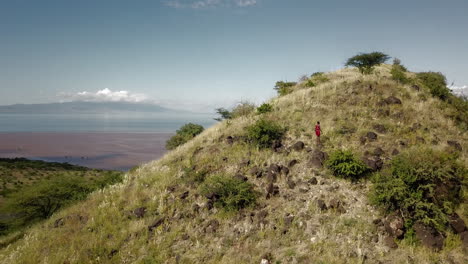 vista aérea frontal de los excursionistas que alcanzan la cima de una montaña en tanzania, áfrica oriental, dando paso a un hermoso paisaje