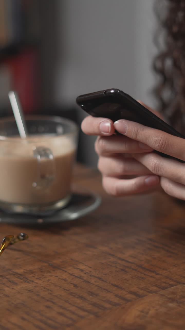 mujer usando un teléfono inteligente en un café