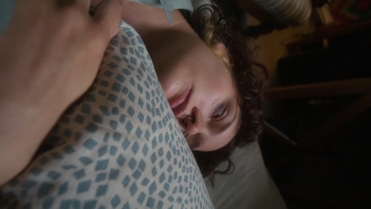 una mujer acostada en la cama, sintiéndose triste.