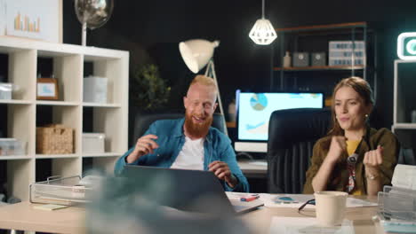 Happy-young-man-and-woman-celebrating-victory-with-laptop-in-office.