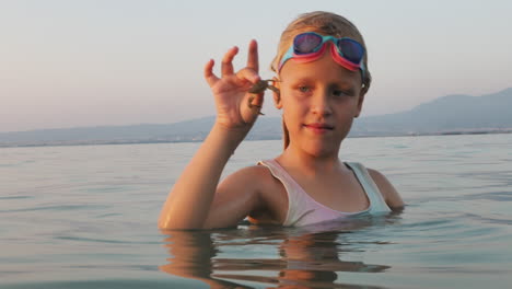 girl holding a crab in the sea