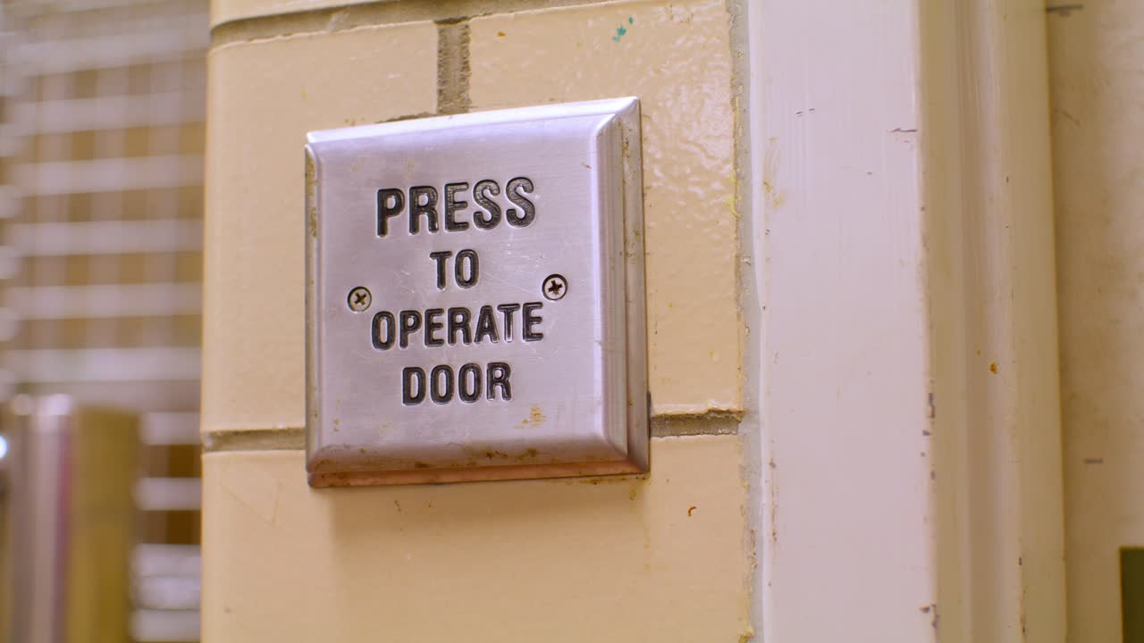 Press to Operate door button on a wall with stable video.