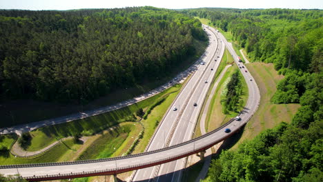 cars driving on elevated highway and expressway between the dense forest in gdynia, poland