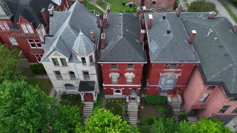 Hileras-De-Casas-Históricas-Con-Distintos-Detalles-De-Ladrillo-Rojo-Y-Piedra-En-Una-Calle-Arbolada