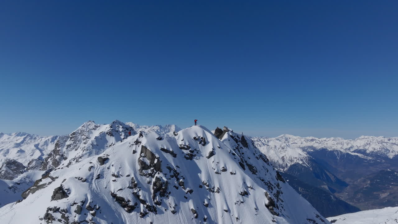 A professional skier hikes up a steep ridge in Verbier, then drops into an epic freeride descent. Pure adventure skiing in deep snow, dramatic terrain, and breathtaking alpine scenery.