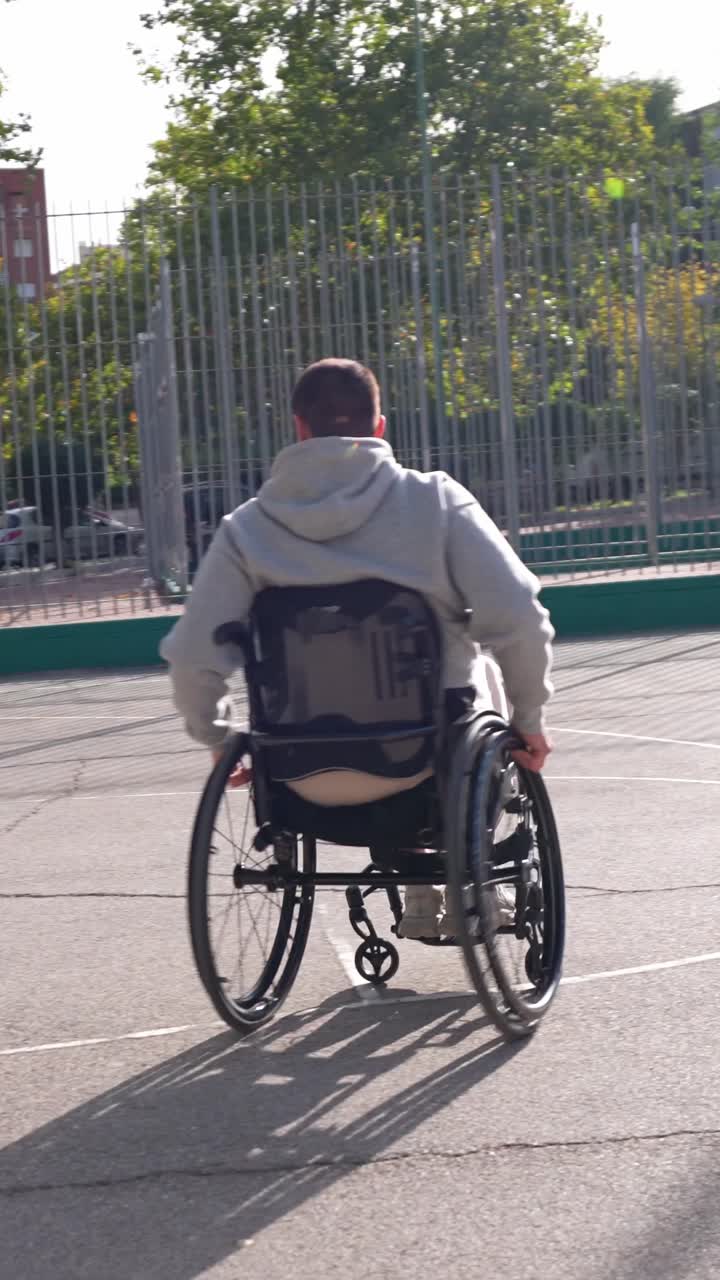 Young Man in Wheelchair Playing Basketball on Outdoor Court