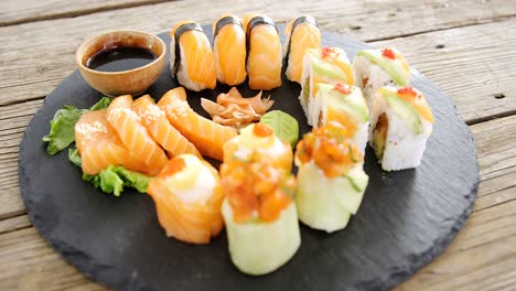 primer plano de varios sushi en bandeja con salsa