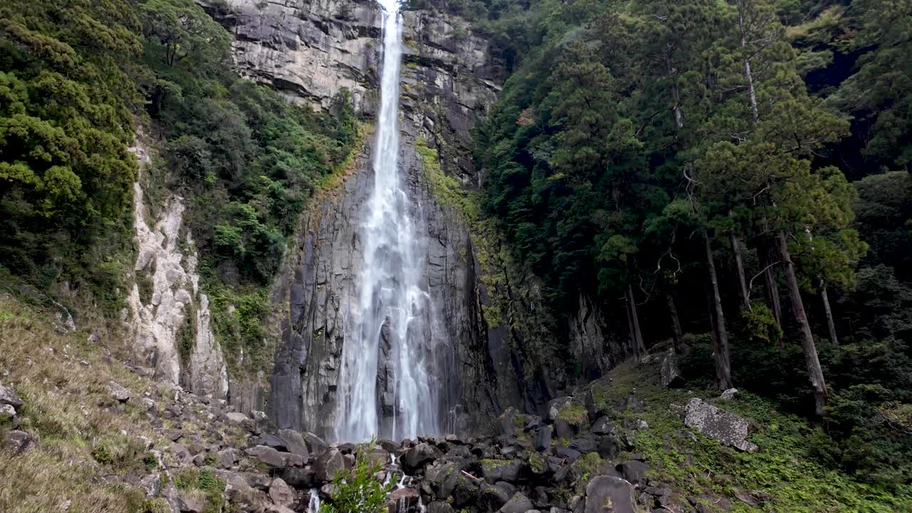 Nachi Falls in Nachikatsuura, surrounded by lush vegetation and rocky terrain. This powerful waterfall is a natural masterpiece, blending with the serenity of the beautiful forest.