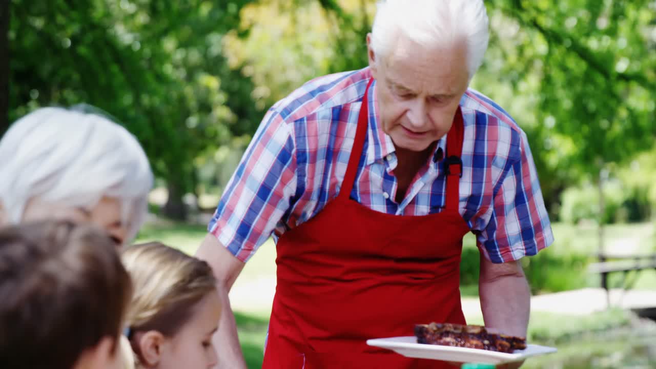 Uomo anziano che serve il pasto alla sua famiglia