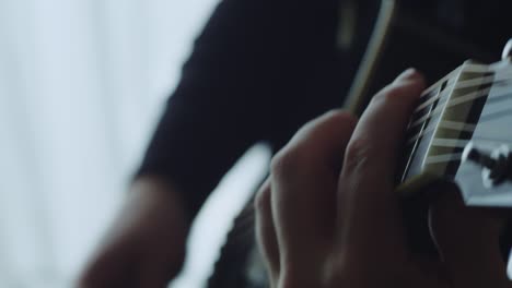 the musician plays the acoustic guitar. closeup of the right hand. macro shooting. depth of field