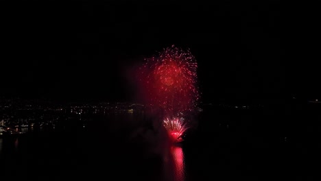 Beautiful-public-fireworks-fired-from-a-ship-in-byfjorden-Bergen-Norway---New-years-eve-midnight-aerial