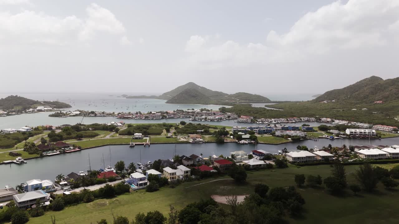Scenic aerial view of Jolly Harbor with lush greenery, residential area, and marina in Antigua