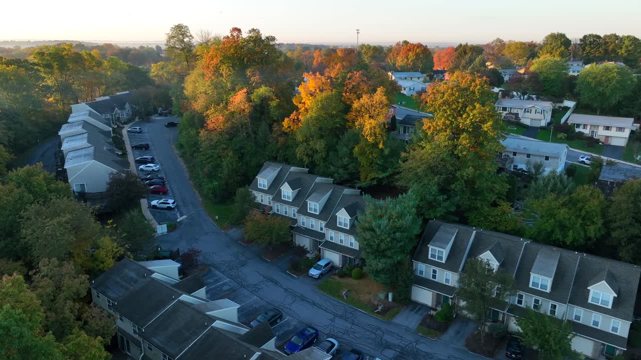 Suburban neighborhood at dawn, townhouses and autumn foliage