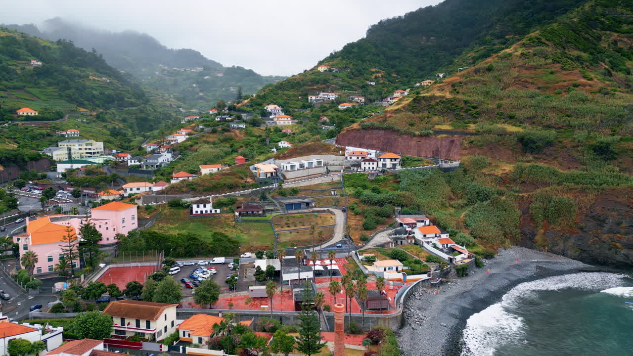 Paesino di droni sulla riva della baia, circondato da pittoresche colline verdi.