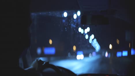 el joven con la máscara médica conduciendo en una carretera nocturna de la ciudad