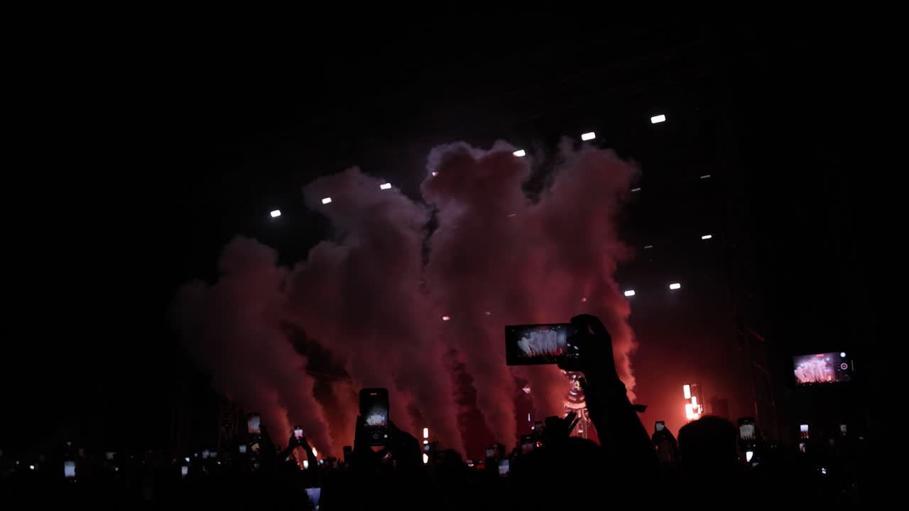 화려 한 야간 콘서트: 화재 와 연기 로 화려 한 애니메이션 무대 의 느린 영상, 흥분 된 군중 들 이 경외 로 박수 를 치는 모습