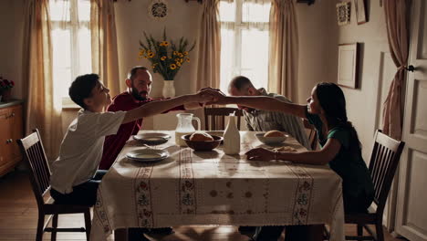 family praying together over dinner