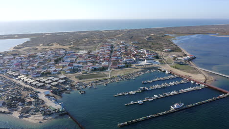 Boats-Moored-At-Culatra-Island-Pier-With-Seaside-Village-At-Daytime-In-Algarve,-Faro,-Portugal