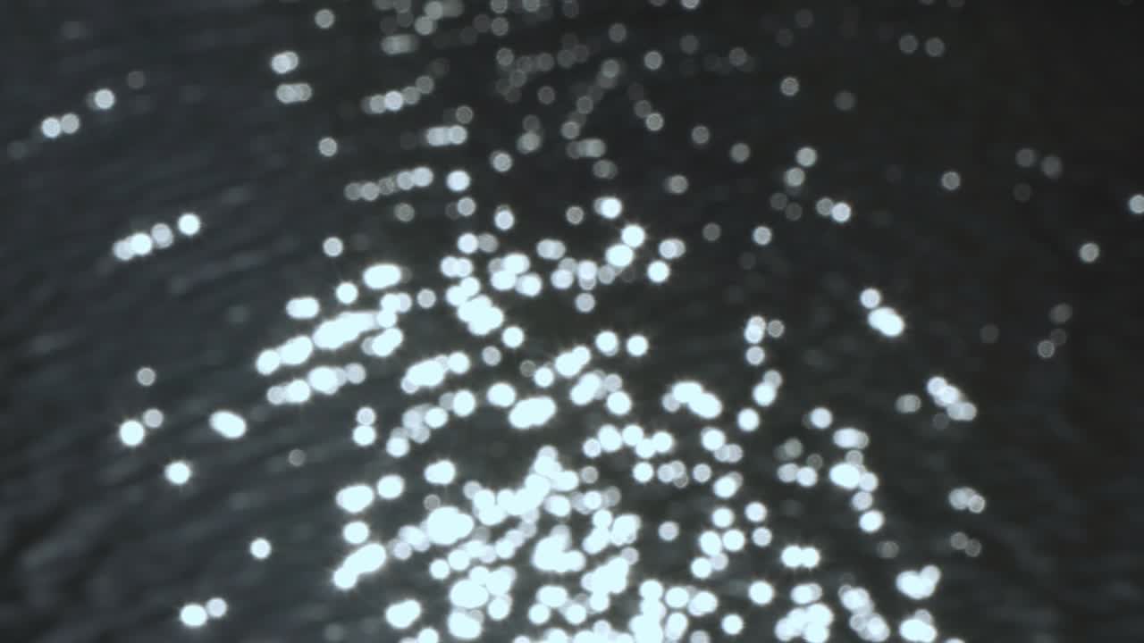 reflejo borroso de la luz solar de la superficie del agua. un ligero movimiento en la superficie está fuera de foco.