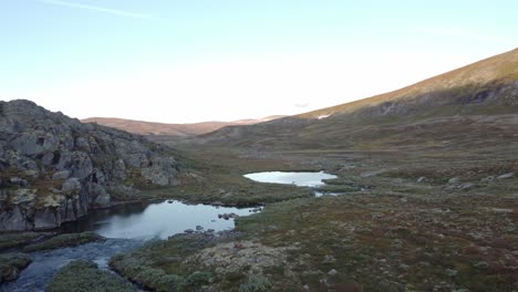 Imágenes-De-Drones-De-Un-Río-Con-Estanques-En-Un-Paisaje-De-Tundra-Escandinavo-A-La-Luz-Del-Atardecer