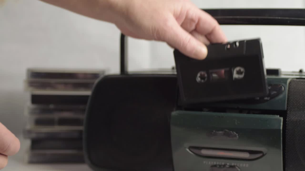 라디오 카세트 플레이어 와이드 샷에 복고풍 카세트 테이프를 손으로 삽입