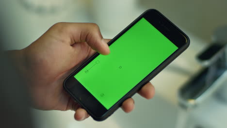 Man-touching-smartphone-with-chroma-key-green-screen.-Mobile-phone