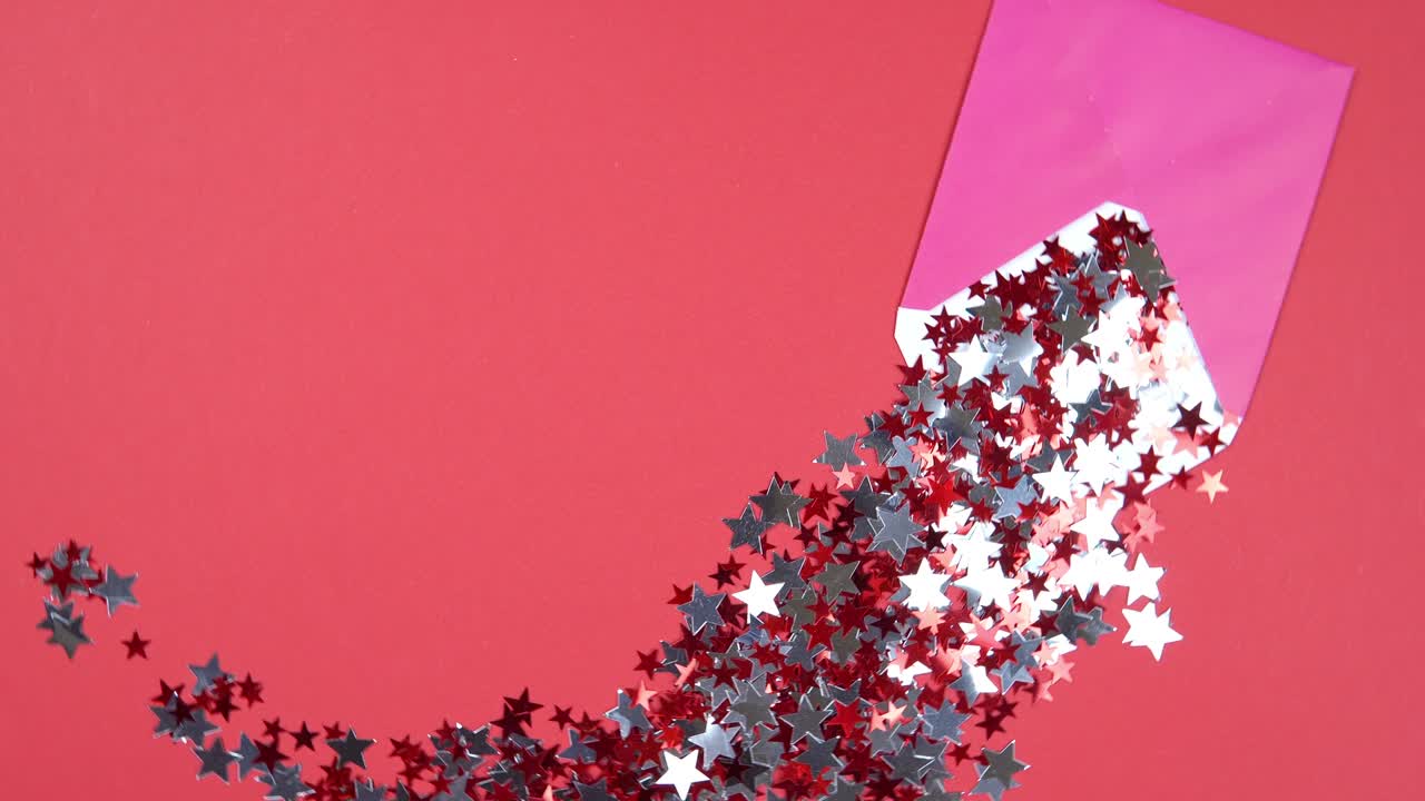 Christmas background 360 degree rotation. The open pink envelope with confetti in form of star spinning on red background